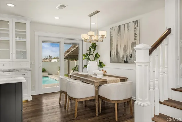 a dining room with furniture a chandelier and wooden floor
