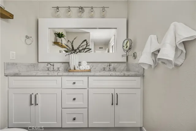 a bathroom with vanity granite and mirror