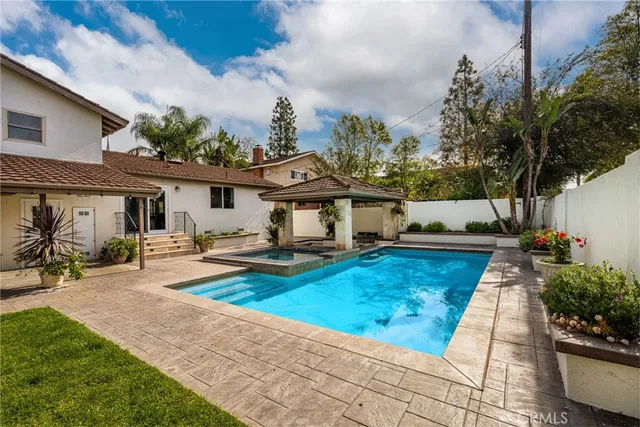 a view of a house with swimming pool and sitting area