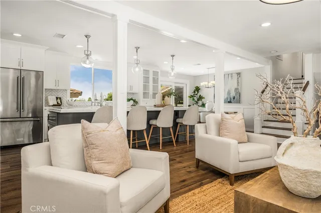 a living room with furniture and a view of kitchen
