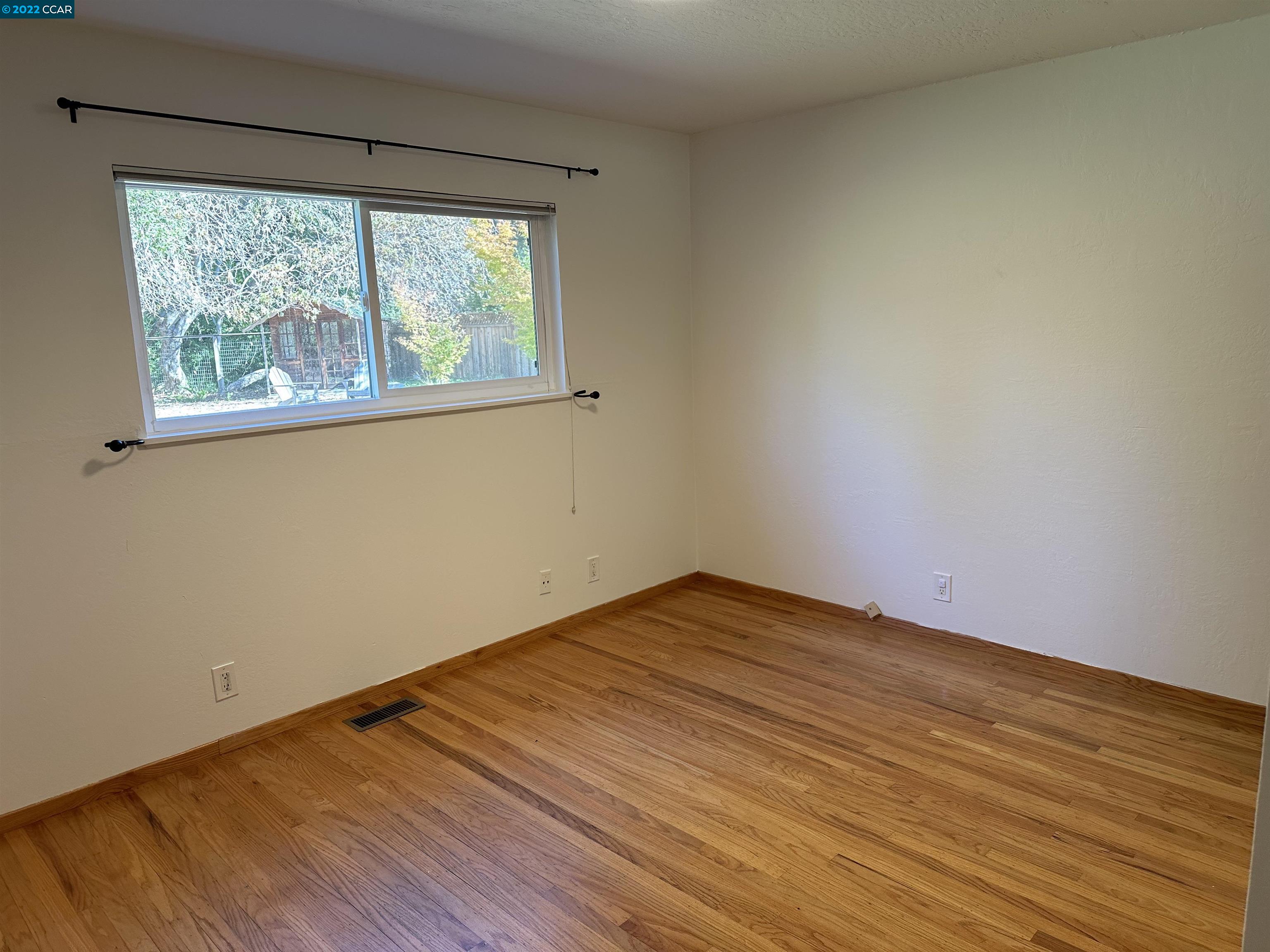 3360 Victoria Avenue Lafayette, CA 94549 - Photo 6 of 20 a view of an empty room with wooden floor and a window