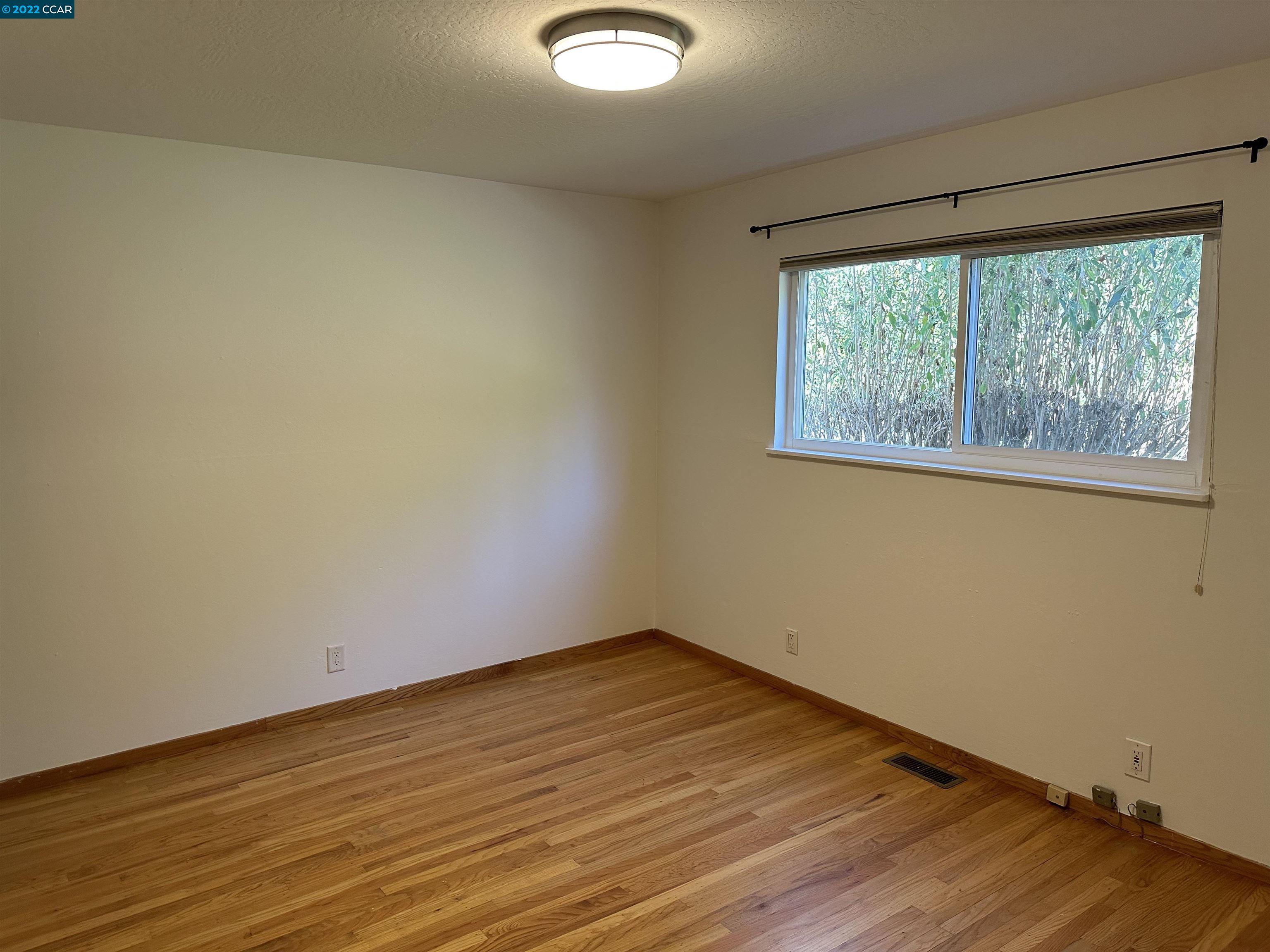 3360 Victoria Avenue Lafayette, CA 94549 - Photo 7 of 20 an empty room with wooden floor and windows