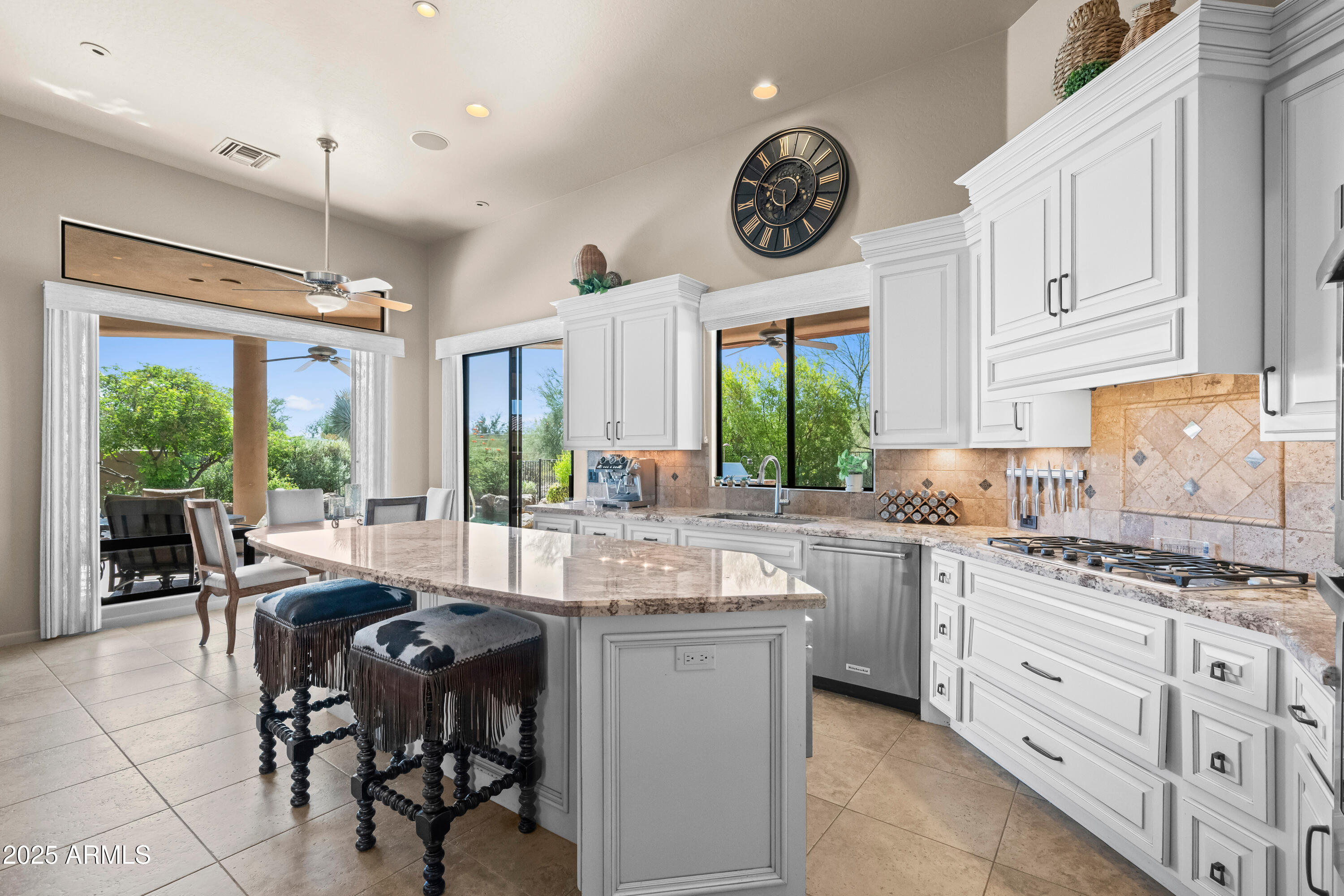 a kitchen with kitchen island granite countertop a stove a sink a dining table and chairs with the large window