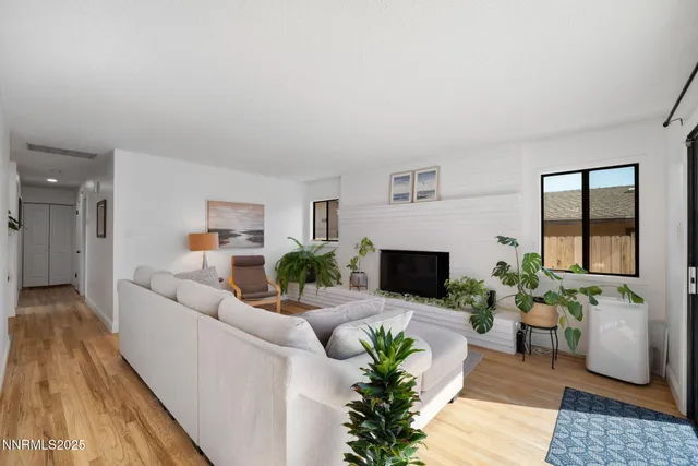 a living room with furniture a potted plant and a fireplace