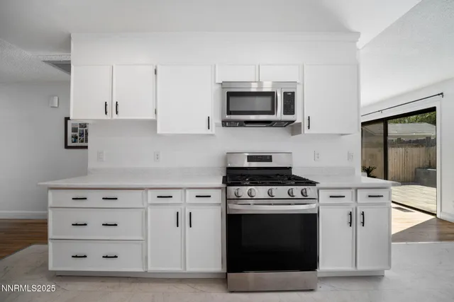 a kitchen with white cabinets and stainless steel appliances
