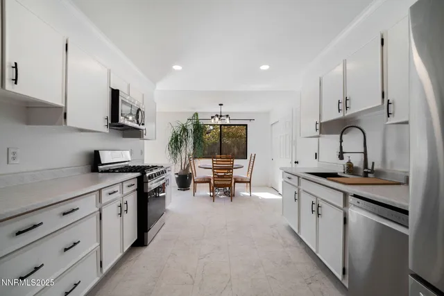a kitchen with stainless steel appliances a sink stove and cabinets