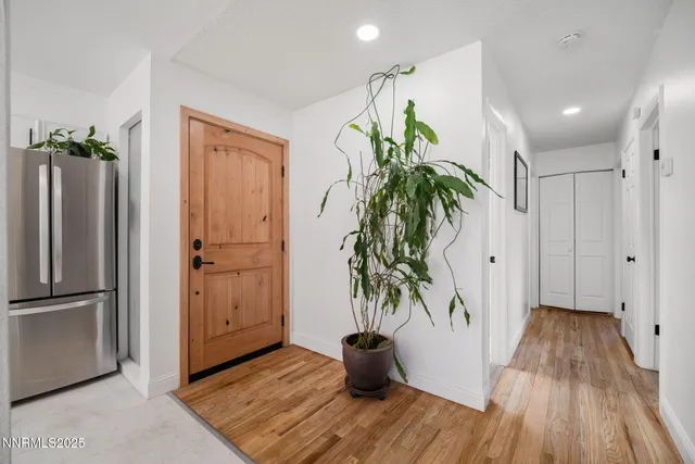a view of a hallway with wooden floor and a potted plant