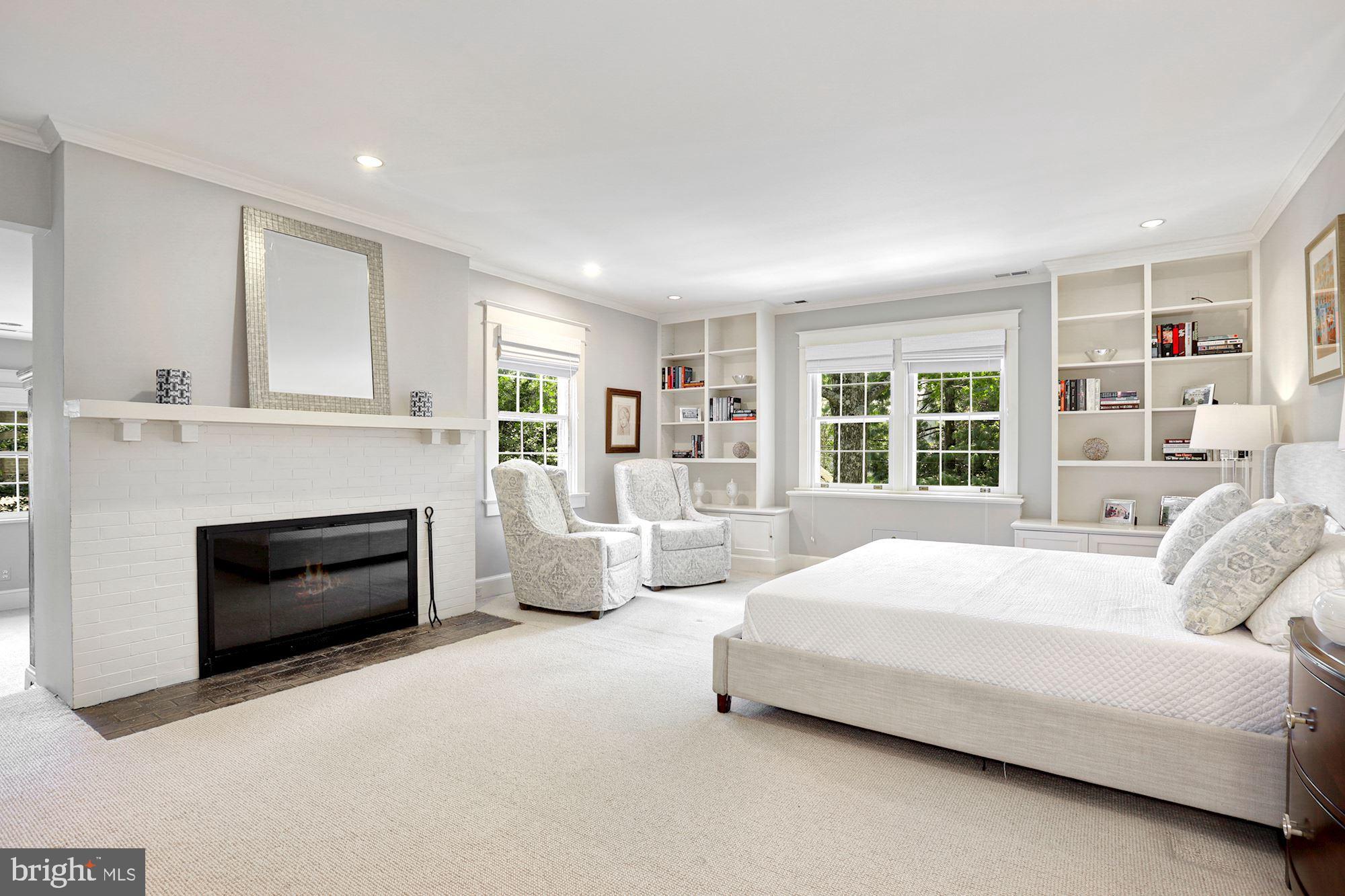 3720 Bradley Lane Chevy Chase, MD 20815 - Photo 17 of 29 a spacious bedroom with a large bed and a fireplace
