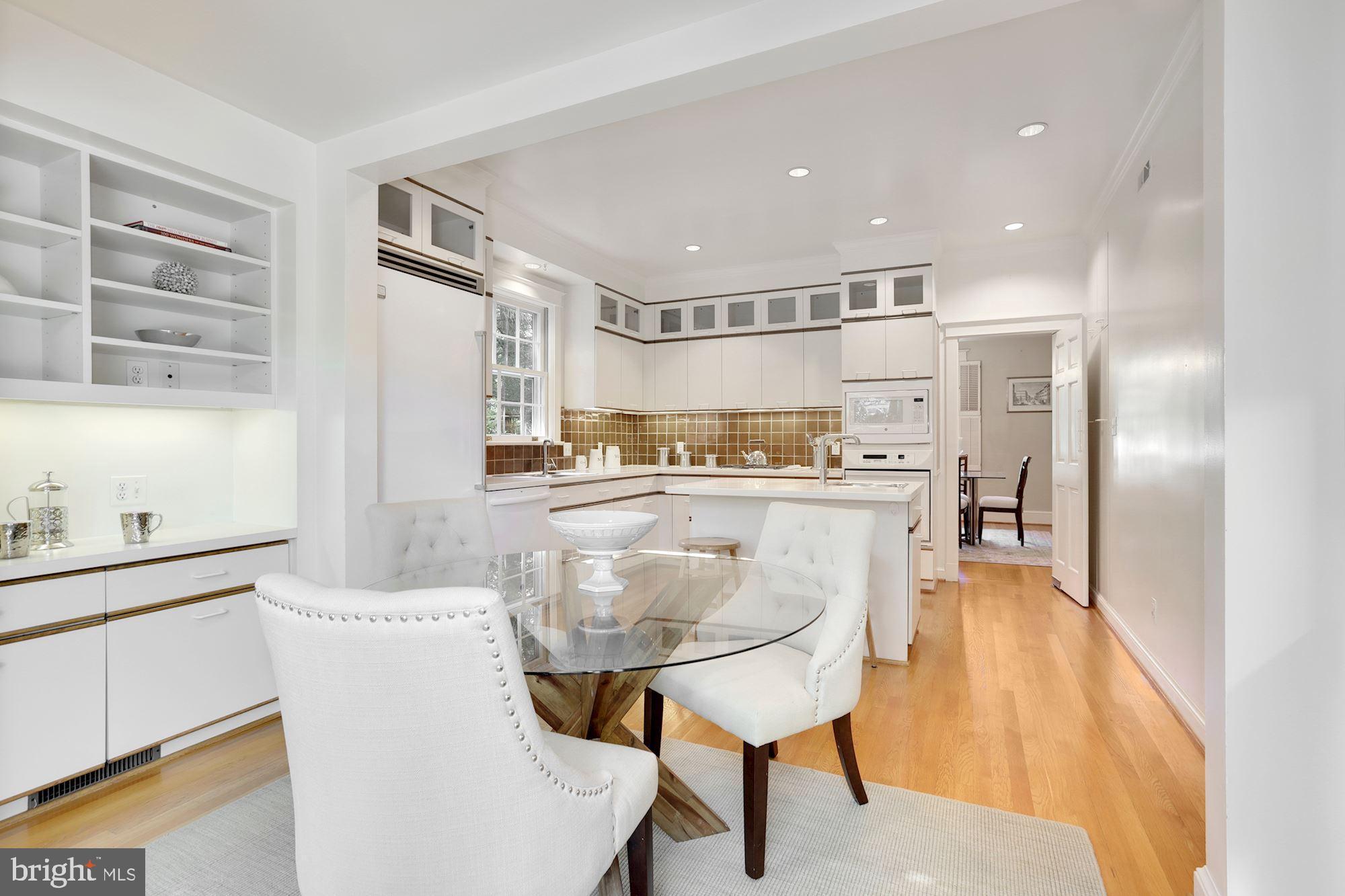 3720 Bradley Lane Chevy Chase, MD 20815 - Photo 10 of 29 a kitchen with stainless steel appliances kitchen island granite countertop a refrigerator a stove a sink and white cabinets with wooden floor