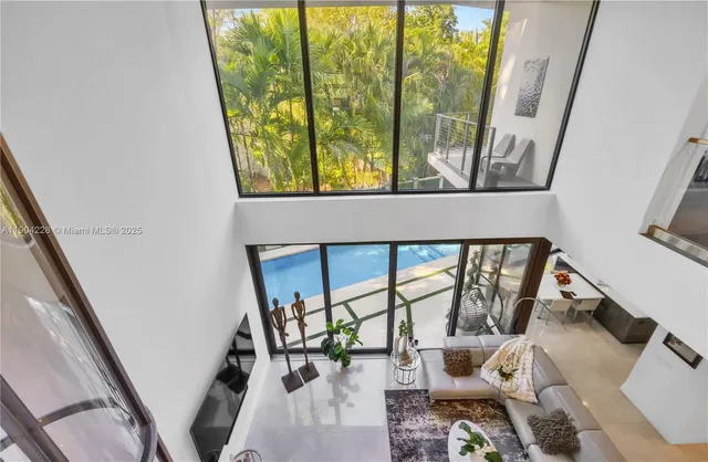 a living room with large windows and stairs