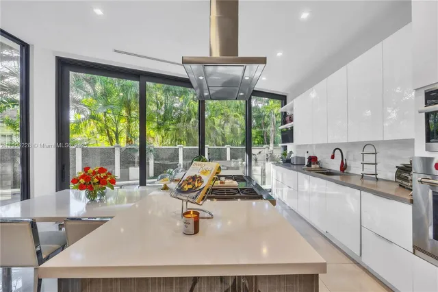 a kitchen with a large window cabinets and dining table