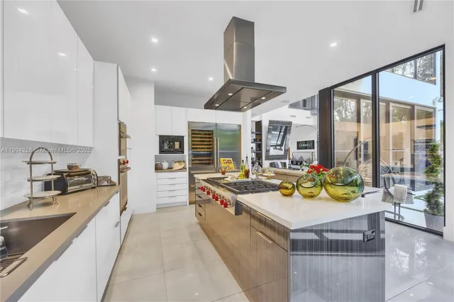 a large white kitchen with a large window and furniture