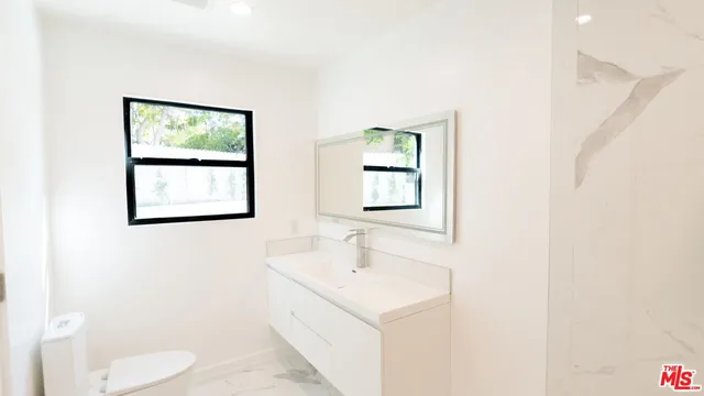 a bathroom with a sink a mirror and a toilet