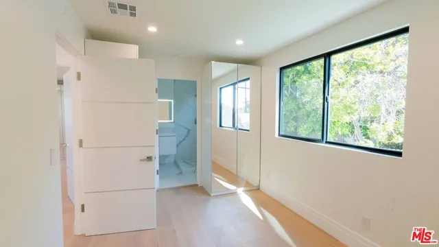 a view of a hallway with wooden floor and white walls