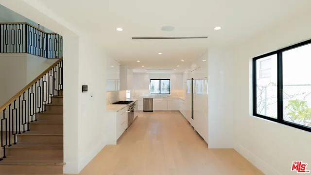 a view of a hallway with wooden floor and staircase