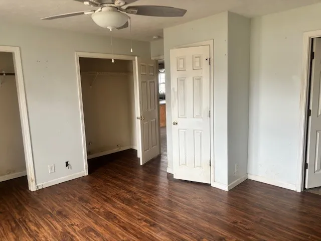 an empty room with wooden floor and mirror