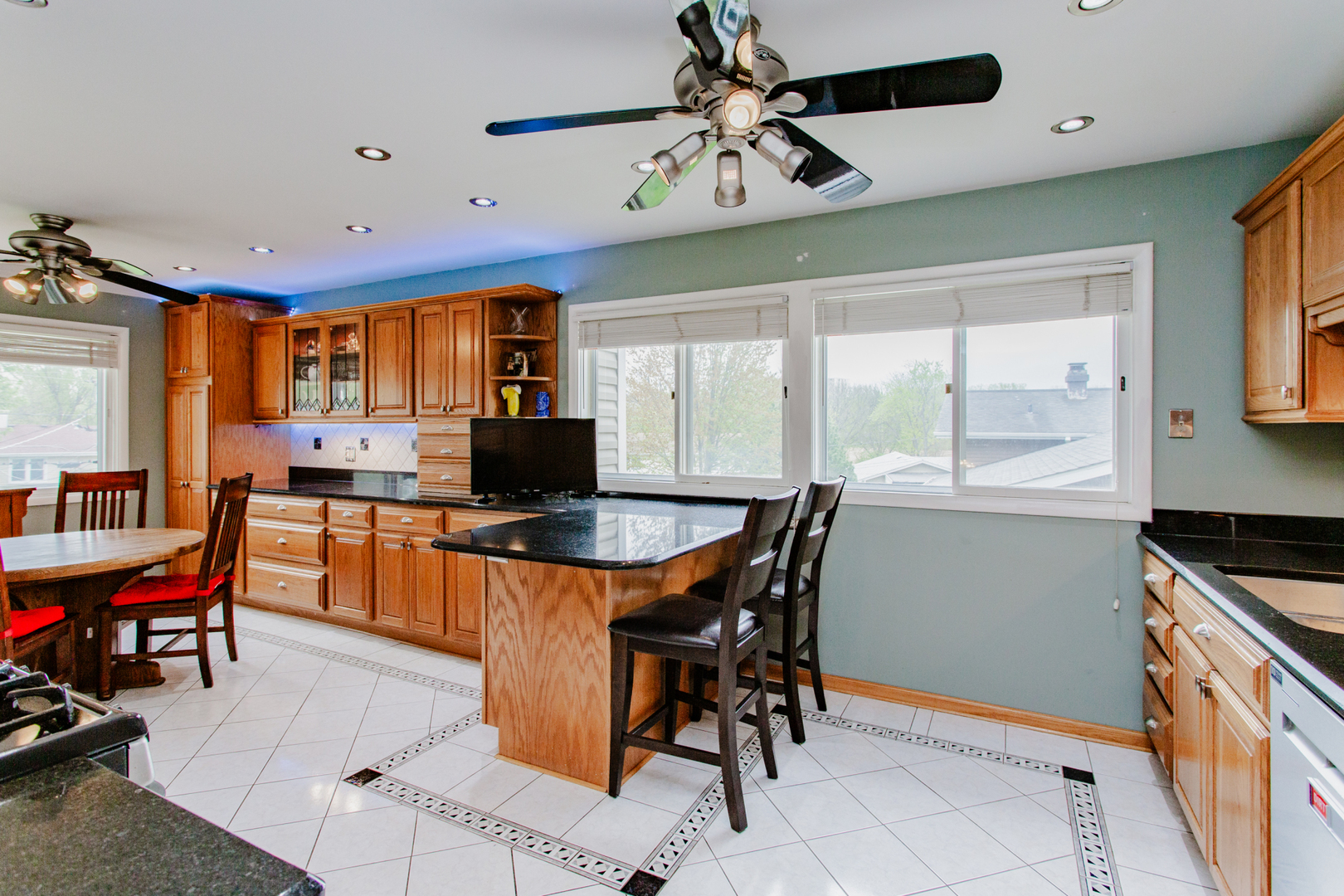 1685 Kent Road Hoffman Estates, IL 60169 - Photo 9 of 31 a kitchen with stainless steel appliances kitchen island granite countertop a table chairs sink and cabinets