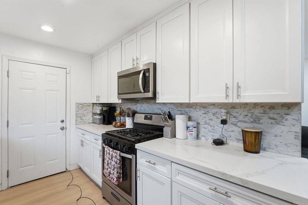 738 Carlsbad Street Spring Valley, CA 91977 - Photo 28 of 40 a kitchen with stainless steel appliances granite countertop a sink a stove a microwave and cabinets