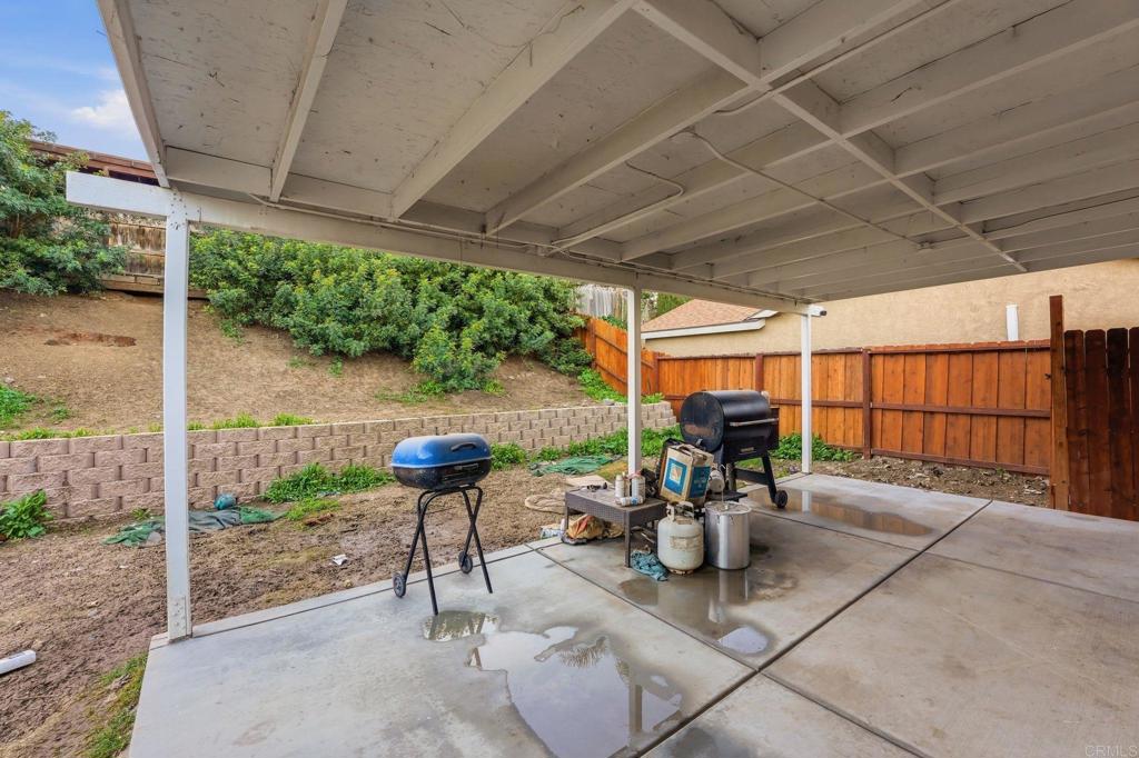 738 Carlsbad Street Spring Valley, CA 91977 - Photo 38 of 40 a view of a patio with table and chairs potted plants with wooden floor and fence