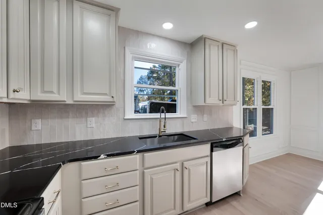 a kitchen with granite countertop a refrigerator and a stove top oven