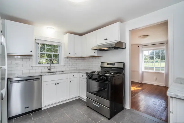 a kitchen with stainless steel appliances a stove sink and cabinets