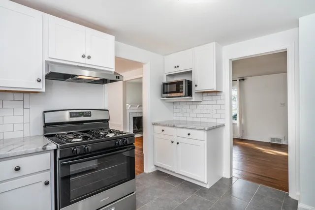 a kitchen with cabinets stainless steel appliances and wooden floor