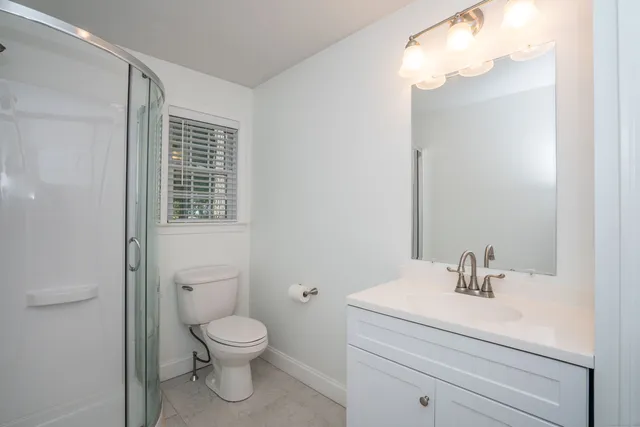 a bathroom with a toilet a sink and mirror