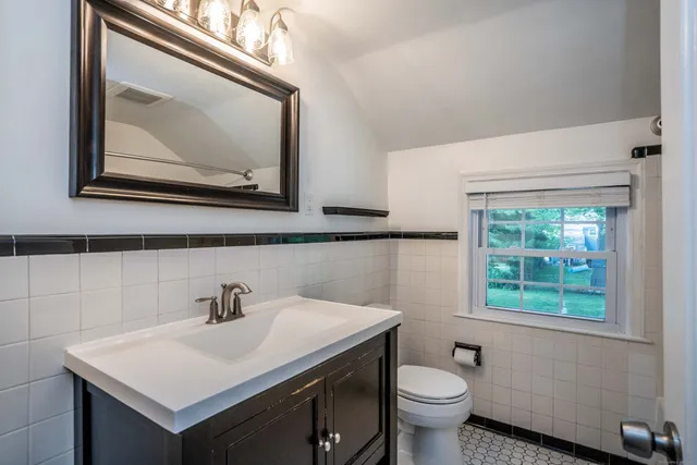 a bathroom with a toilet sink and mirror