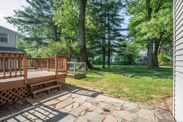 a view of backyard with deck and outdoor seating