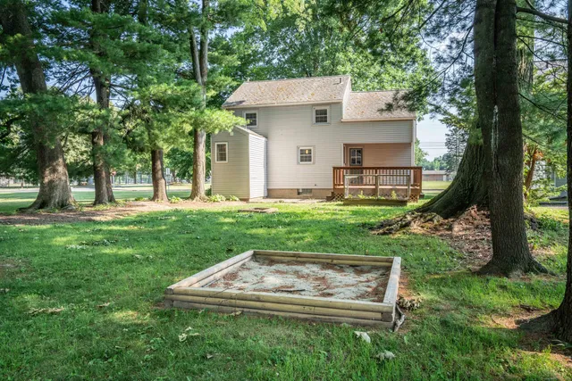 a view of a house with backyard and trees