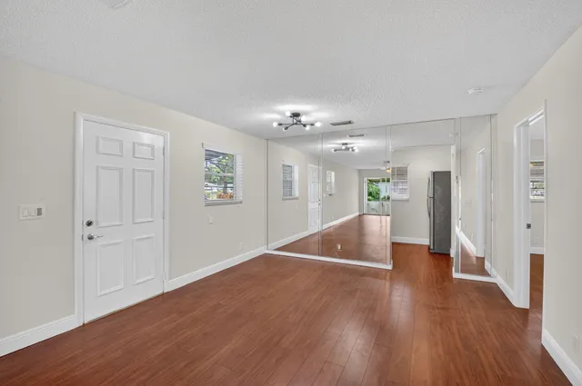 a view of a hallway with wooden floor and chandelier