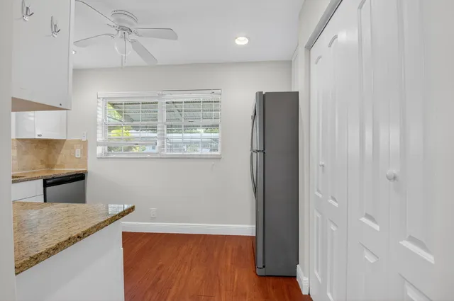 a kitchen with a refrigerator and a stove top oven