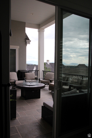 7 Elk Court Alpine, UT 84004 - Photo 5 of 10 Covered patio featuring large format stone tile, an integrated fire pit, and a black metal railing