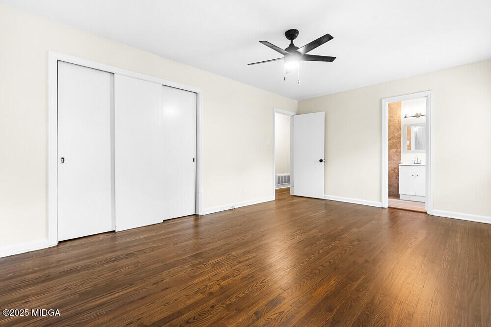 127 Edna Place Warner Robins, GA 31093 - Photo 15 of 26 an empty room with wooden floor and a ceiling fan