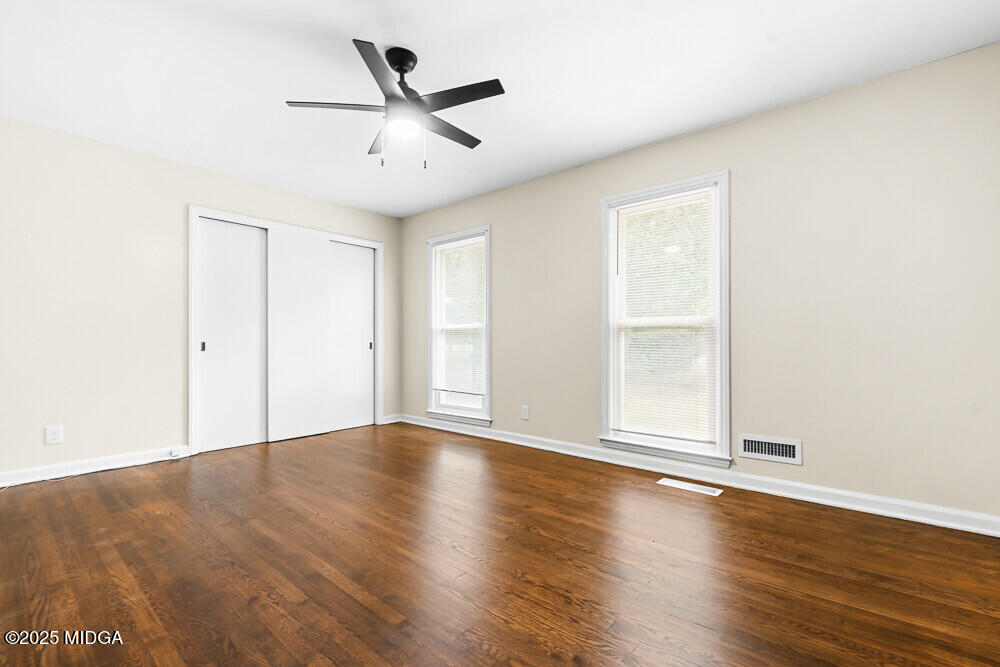 127 Edna Place Warner Robins, GA 31093 - Photo 19 of 26 an empty room with wooden floor ceiling fan and windows