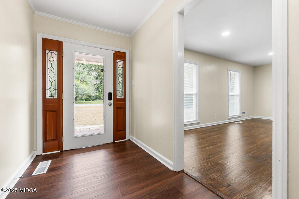 127 Edna Place Warner Robins, GA 31093 - Photo 4 of 26 an empty room with wooden floor and windows with curtains