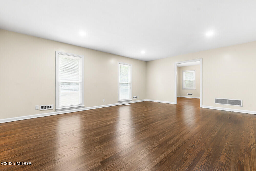 127 Edna Place Warner Robins, GA 31093 - Photo 5 of 26 an empty room with wooden floor and windows