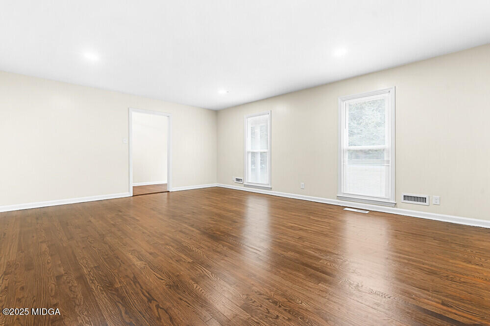 127 Edna Place Warner Robins, GA 31093 - Photo 6 of 26 an empty room with wooden floor and windows