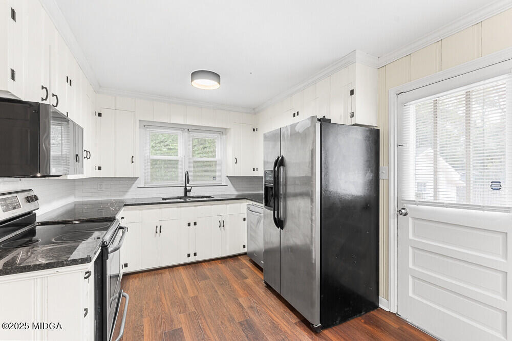 127 Edna Place Warner Robins, GA 31093 - Photo 9 of 26 a kitchen with stainless steel appliances granite countertop a refrigerator a sink a stove and white cabinets with wooden floor