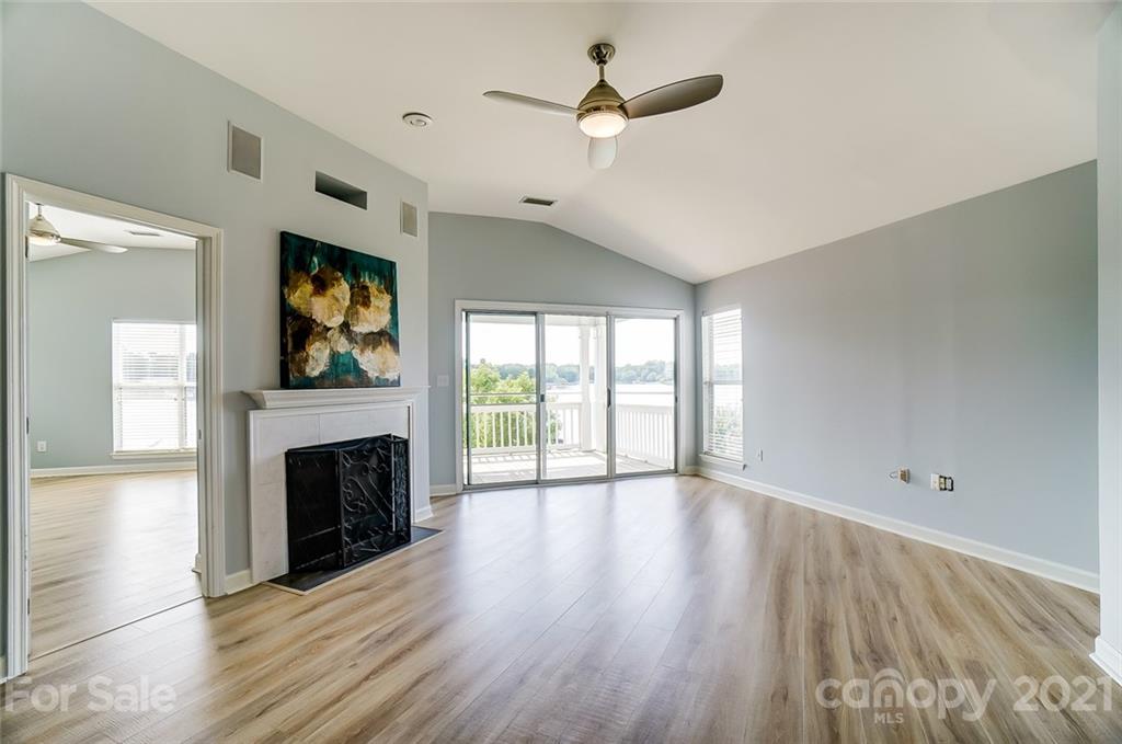 1342 Torrence Circle Davidson, NC 28036 - Photo 15 of 39 an empty room with windows fireplace and a ceiling fan