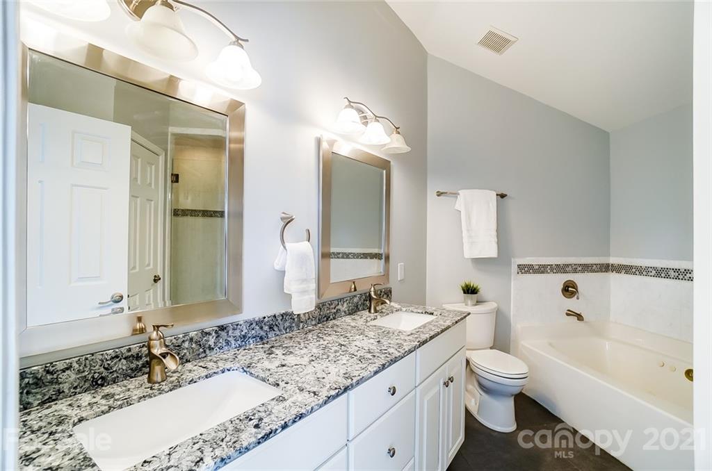 1342 Torrence Circle Davidson, NC 28036 - Photo 20 of 39 a bathroom with a granite countertop sink toilet mirror and bathtub