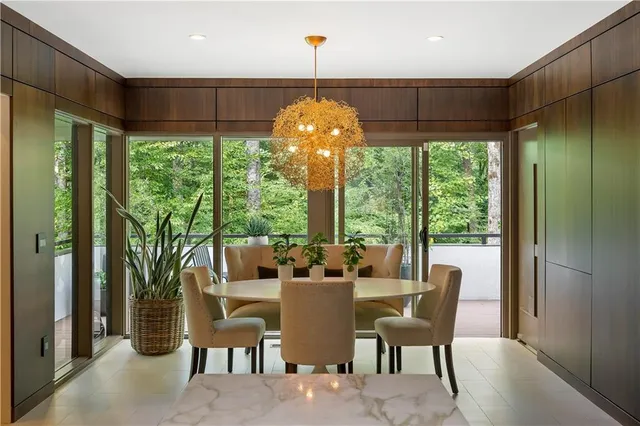 a living room with furniture a flat screen tv and a refrigerator