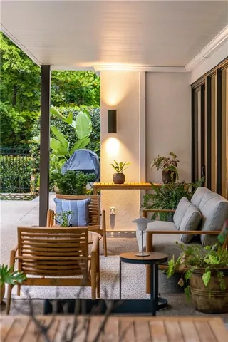 a view of a patio with table and chairs potted plants and large tree