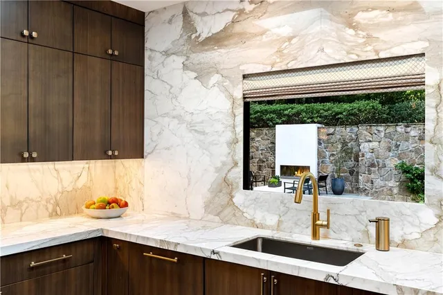a kitchen with kitchen island a counter space a sink appliances and cabinets