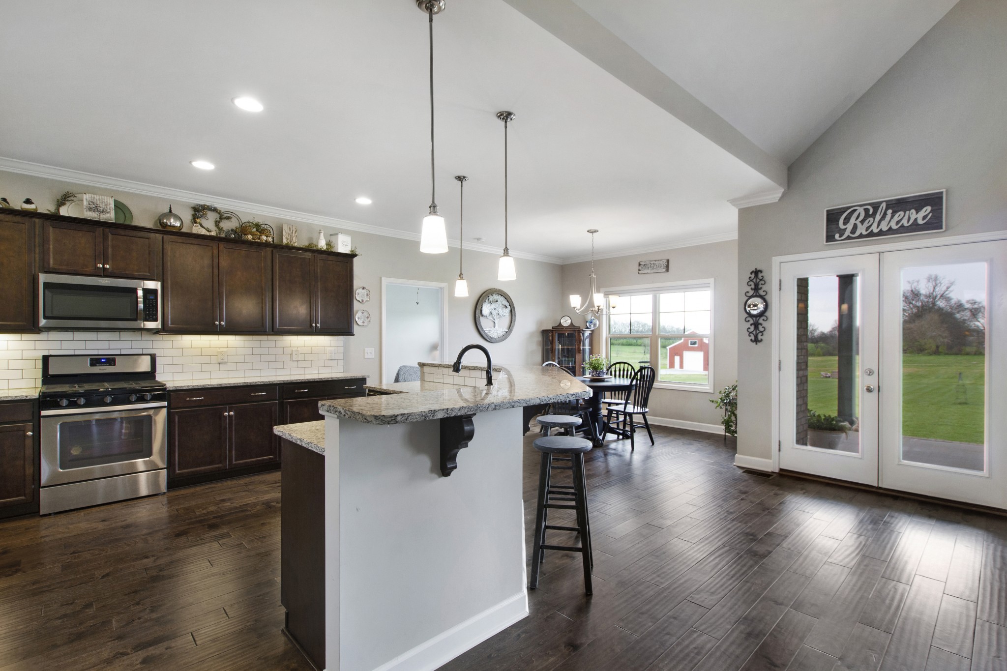 1091 Caballo Trail Gallatin, TN 37066 - Photo 7 of 30 a kitchen with stainless steel appliances granite countertop a stove top oven a sink dishwasher a dining table and chairs with wooden floor