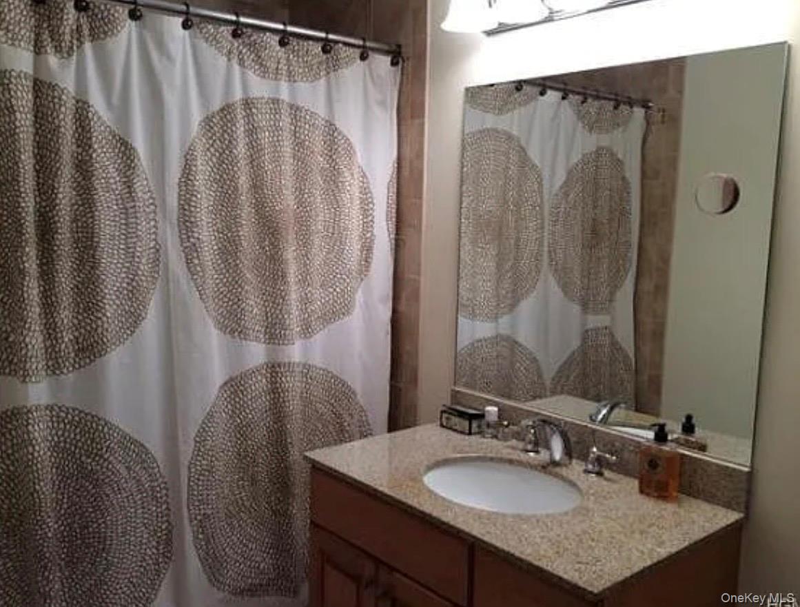 3 Cross Street, Unit 304 Suffern, NY 10901 - Photo 12 of 18 a bathroom with a granite countertop sink and a mirror