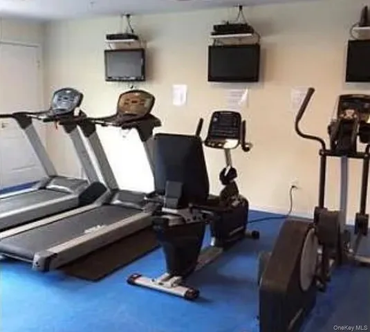 a room with gym equipment and wooden floor