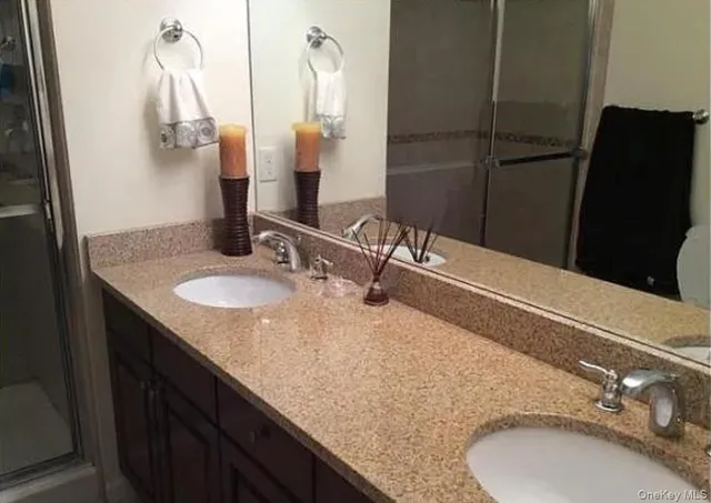 a bathroom with double vanity and a mirror