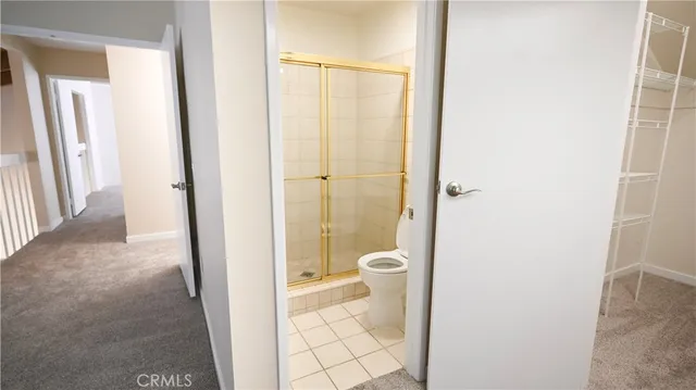 a bathroom with a granite countertop shower and a toilet