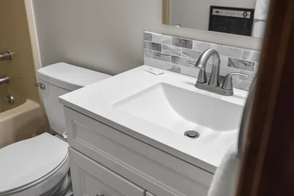 a bathroom with a toilet a sink and mirror